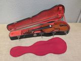 a violin case with a violin in it and a pink slip