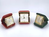 three small clocks sitting on a table with a white background
