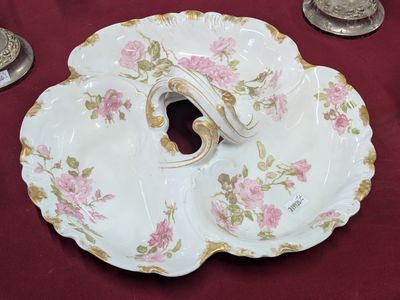 une assiette blanche ornée de fleurs roses, posée sur une table rouge