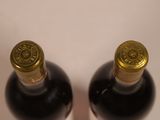 two bottles of wine sitting next to each other on a table