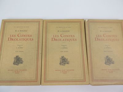 trois livres sont posés sur une table blanche