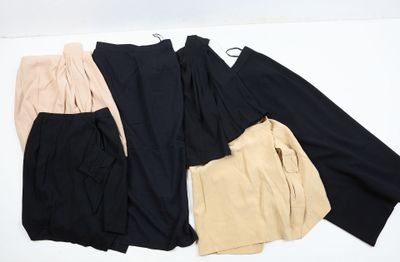 trois paires de pantalons noirs, beiges et beiges posées sur une surface blanche