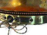 a brass plate with a rope around it on a white surface