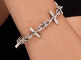 un bracelet en argent en forme de croix au poignet d'une femme