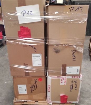 de nombreux cartons empilés les uns sur les autres dans un entrepôt
