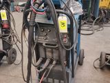 two welding machines in a garage with other equipment