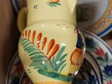 a yellow vase sitting on top of a pile of plates