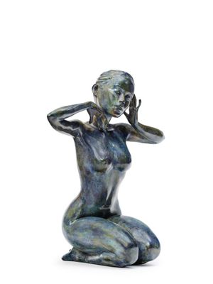 statue of a woman sitting on her knees with her hands on her head