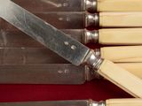 five knives in a case that are sitting on a table
