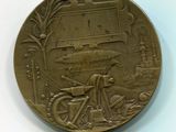 une médaille d'or sur laquelle figure l'image d'un homme à vélo