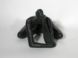 statue représentant un homme assis à genoux sur une surface blanche