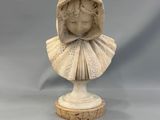 un gros plan sur la statue d'une femme portant une capuche