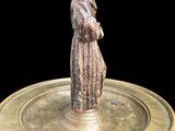 a statue of a man standing on a brass plate