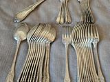 silverware is laid out on a gray cloth with a spoon and fork