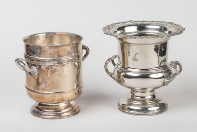 two silver vases sitting next to each other on a table