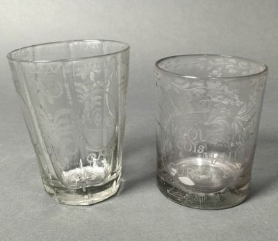 pair of glass tumblers with etched designs on them on a gray surface