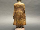 an image of a statue of a person standing on top of a wooden block