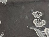 a black and white photo of a glass plate with flowers on it