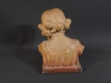 a small statue of a woman sitting on a table