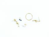 three pairs of gold earrings and a ring on a white surface