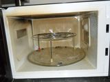 a microwave with a glass door and a metal rack in it