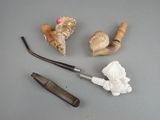 une pipe, un porte-pipe et quelques autres objets posés sur une table