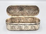 an antique silver box with a dragon design on the lid