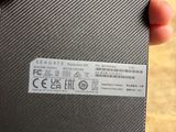 a person holding a small black box with a sticker on it