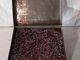 une boîte en métal contenant un tas de perles