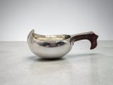 an image of a silver pitcher with a wooden handle on a table