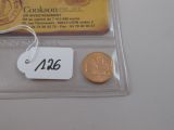 une pièce et une carte posées sur une table, avec une étiquette indiquant le prix