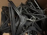 une boîte en carton remplie d'une multitude de cintres noirs