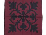 a red and black square with a black design on it