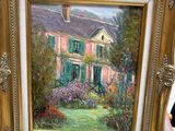 une photo d'un tableau représentant une maison, posé sur une table
