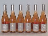 six bouteilles de vin sont alignées sur une table