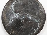 a black plate that has some white paint on it