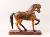 statue of a horse on a wooden base against a white background