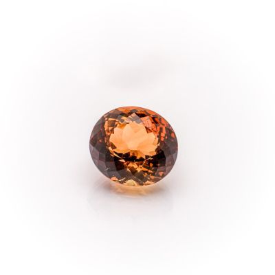 an orange sapphire stone on a white background