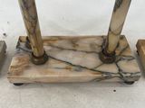 three pieces of marble with a clock in the background