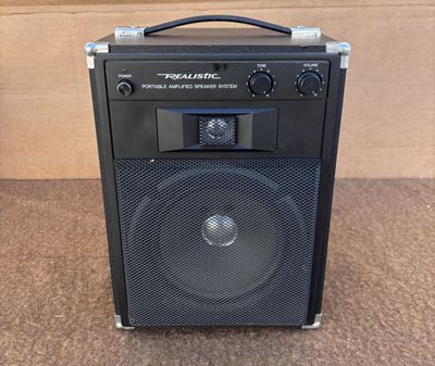 un gros plan d'une enceinte posée sur une table près d'un carton