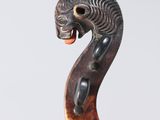 a close up of a wooden stick with an animal head on it