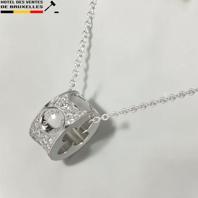 un gros plan d'une bague en argent ornée d'une perle suspendue à une chaîne