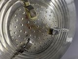 a metal bowl with a clock on it on a table