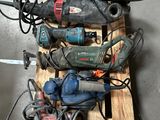 un tas d'outils électriques posés sur une palette au sol