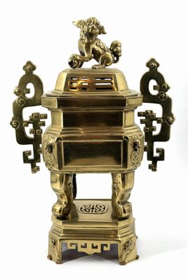 a gold incense box with a dragon on top