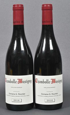 two bottles of red wine sitting next to each other on a table