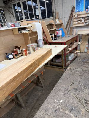 un établi dans un atelier de menuiserie où se trouvent de nombreux outils
