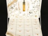 une boîte ouverte contenant un flacon de parfum, sur fond noir