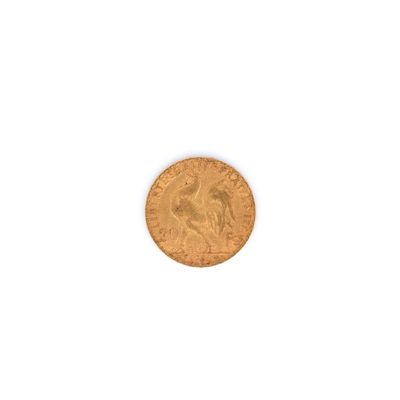 gros plan d'une pièce d'or sur une surface blanche