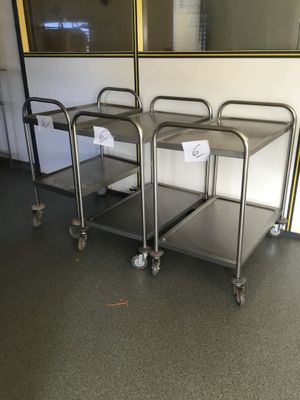 three stainless steel trolleys sitting in the middle of a room